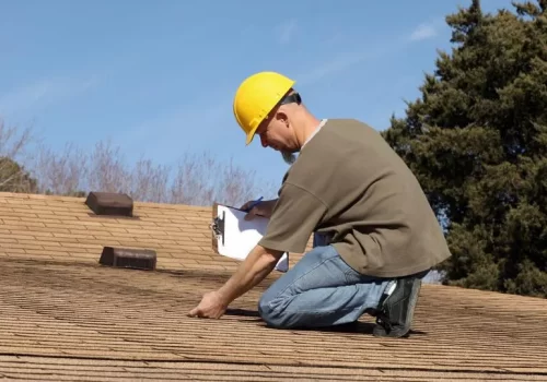 Professional roof inspector with clipboard checking a home Professional roof inspector with clipboard checking a home
