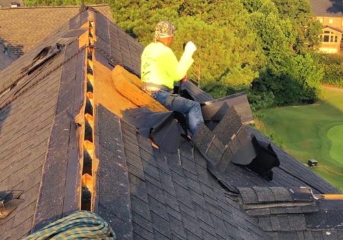 Roofing contractor repairing shingles on a steep roof Roofing contractor repairing shingles on a steep roof