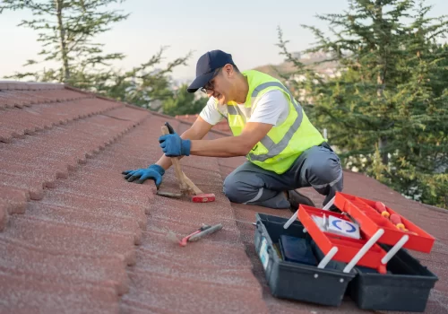 Roofing contractor inspecting shingles on a home roof Roofing contractor inspecting shingles on a home roof
